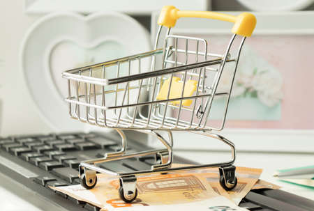 Shopping online concept - Parcel or Paper cartons with a shopping cart logo in a trolley on a laptop keyboard. Shopping service on The online web. offers home delivery ..の写真素材