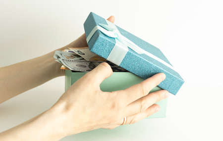 Open gift box with a big gold money coin inside on the table. Money Gift Concept.の写真素材