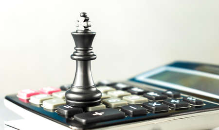 Chessmen queen and king in front of the battlefield of fallen chess pieces sacrifices, black...