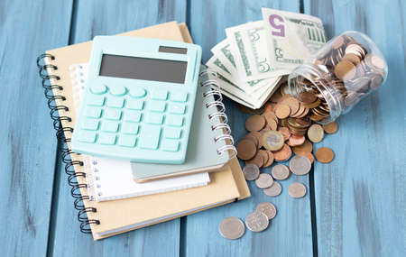 Money, coins, calculator and some stationery on wood table, top view with copy space - financial background conceptの写真素材