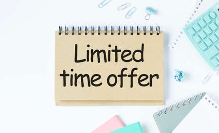 Limited time offer, Text message on white paper with notebook on wooden table, top view. business conceptの写真素材