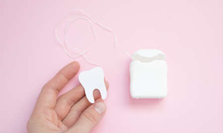 Dental hygiene and oral health concept with a dental floss box isolated on plan backgroundの写真素材