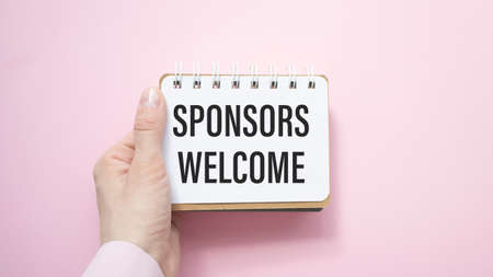 Businessman holding a card with text Sponsors Welcomeの写真素材