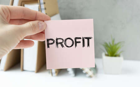 Stickers on notebook text PROFIT with pen and glasses on the white backgroundの写真素材