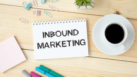 In the notebook is the text INBOUND MARKETING, next to the magnifying glass and pen.の写真素材