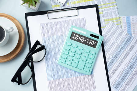 Word 1040-Tax on calculator. Business and tax concept on white background. Top view.の写真素材