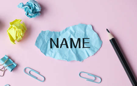 Name text on a crumpled piece of paper with pencil and paper clips.の写真素材