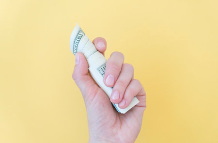 Pack of one hundred dollar bills in femle hands with copy space. Top view of money saving concept on...