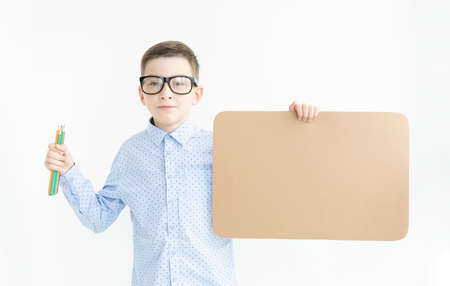 A cute boy-child holds a white banner for inscriptions in his hands. Mockup