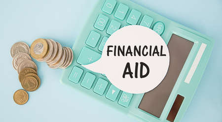 Financial Aid - text written on a notebook with office backgroundの写真素材