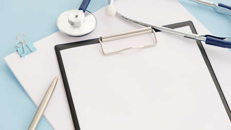 Stethoscope and tablet for recording patients on blue background