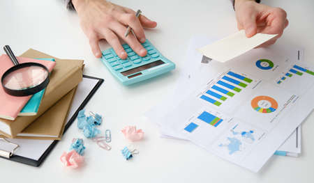 Asian male finance staff is calculating the investment results to deliver a report to his supervisor...