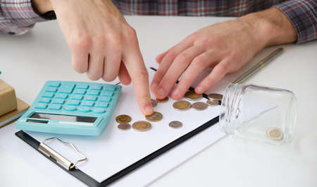 Businessman counting coins and using calculator. Business. Finance