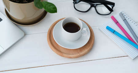 Top view with copy space, working desk with laptop, cellphone, notebook pencil and coffee in the...