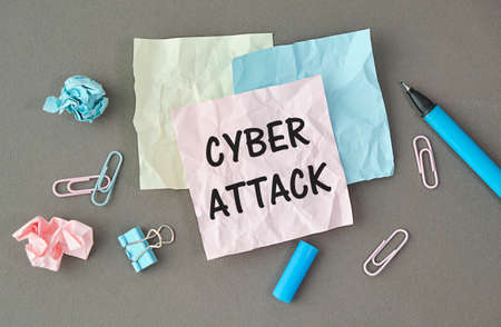 Cyber attack text on paper on gray background.
