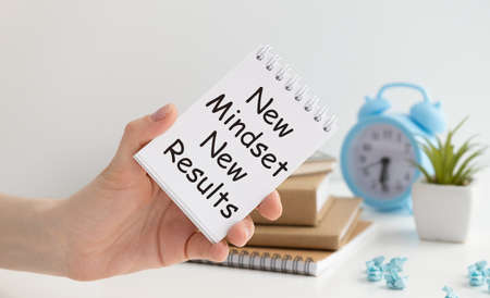 New mindset new results words letter, written on notepad, work desk top view. Motivational self development business typography quotes concept.の写真素材