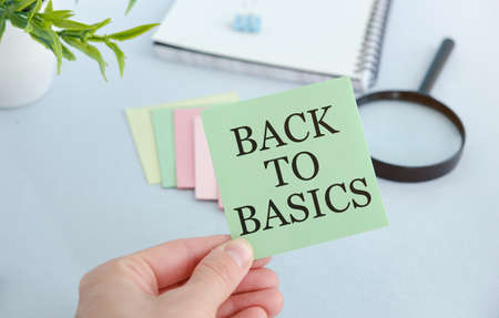 The businessman keeps a card with the text BACK TO BASICS.