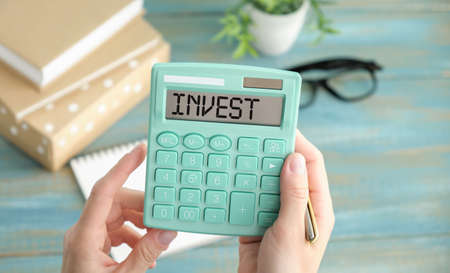 On the table are white cubes, a black basket and a calculator with the inscription - Invest.の写真素材