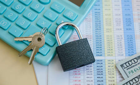Lock with keys on a calculator next to financial calculations. The concept of financial difficulties and sanctions. financial security concept.の写真素材