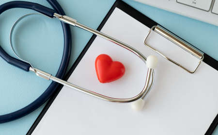 Stethoscope, Heart, Keyboard And Notepad On Tile Background.
