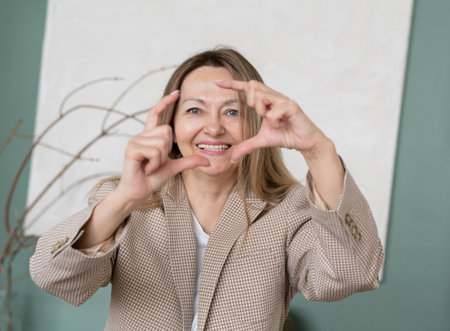 Photo of happy positive nice charming old woman sit couch good morning smile indoors inside house homeの写真素材