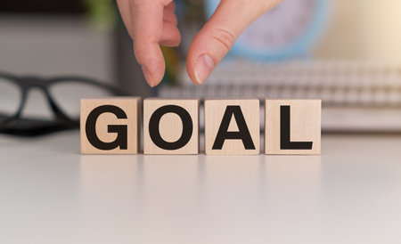 Person's Finger And Goal Text On Wooden Blockの写真素材