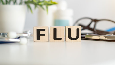 text flu on wooden blocks on a gray backgroundの写真素材