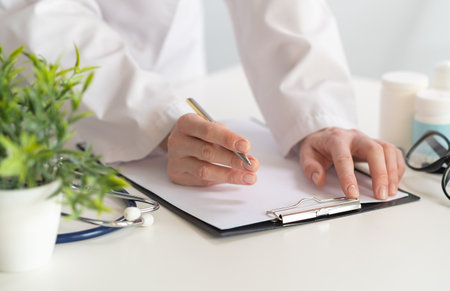 Doctor makes notes on medical records closeup, medical concept.の写真素材
