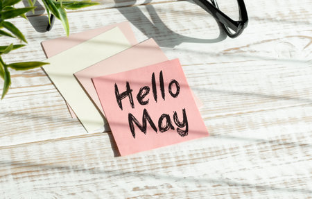 Hello May. text on white notepad paper on wooden background.の写真素材