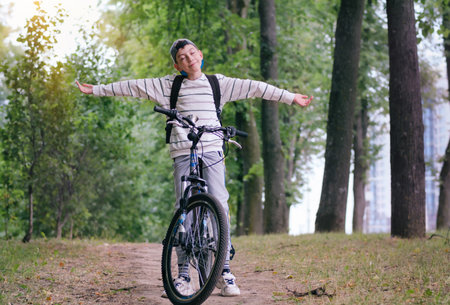 Active child making sports. Safety, sports, leisure with kids concept. A teen boy rides his mountain bike on a trailの写真素材