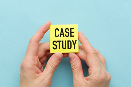 Case Study text on yellow message card with hands on blue backgroundの写真素材