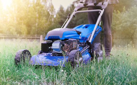 Gardener mowing the lawn. Landscape design. Green grass backgroundの写真素材