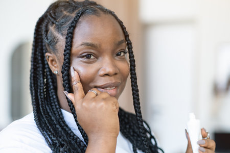 Cream, moisturizer and facial black woman in skincare, beauty or cosmetics promotion against a white wall. Face, calm and people generation or model lotion, sunscreen or skin care moisturizerの写真素材