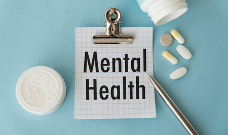 Mental Health text on paper with pen and pills on blue background, Medical Concept.の写真素材
