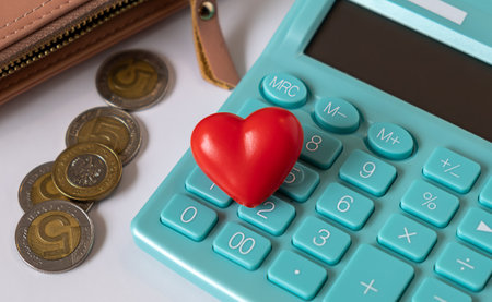 Red heart on calculator with coins and wallet on table, Valentine's Day gift planning on a budget,...