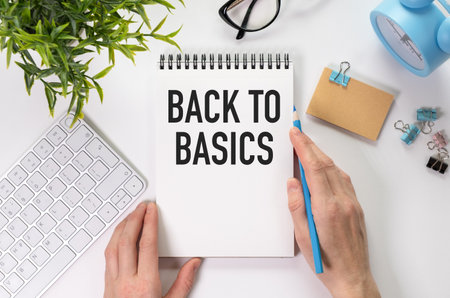 Notepad with text back to basics on table with chopsticks, white paper clips and crumpled sheets.の写真素材
