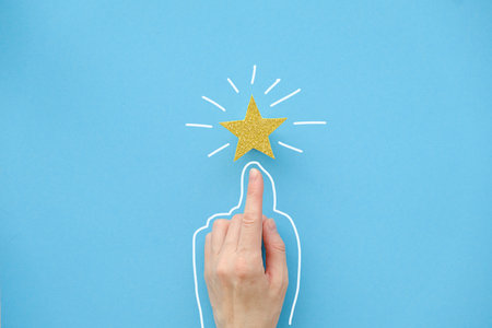 The finger of the hand points to a shiny star on a blue background. Best Customer Experience Concept in Business Services Ratingの写真素材