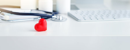 Stethoscope and red heart on light white background with space for text. Cardiology conceptの写真素材