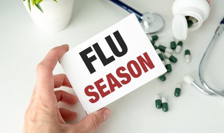 Text Flu Season text on a medicine box on the doctor's notepad next to it is a stethoscopeの写真素材