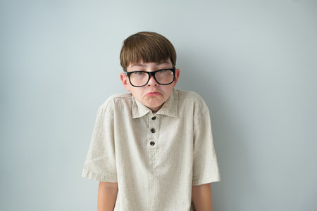 Children's thinking. Boy thinking about a solution, isolated on a light background. Uncertainty, expression of doubt, confusion, inspiration and solution concept.の写真素材