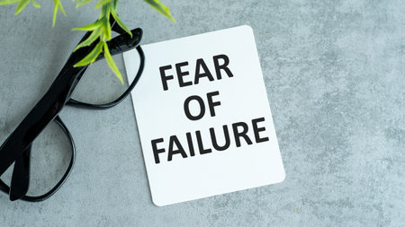 FEAR OF FAILURE text on paper notebook with chart and glasses business conceptの写真素材