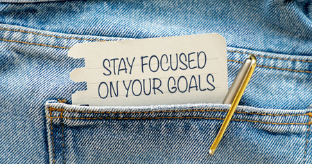Inspirational Quote: Stay Focused on Your Goals. With text message on white paper in pocket with hand on blue jeans backgroundの写真素材