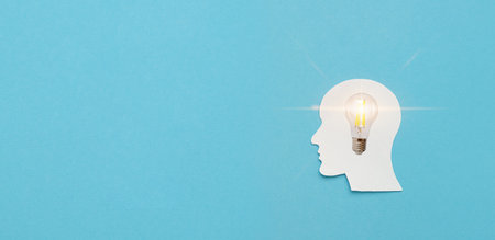 Men's paper figurine head and illuminated light bulb of new ideas with innovative technology and creativity, copy spaceの写真素材