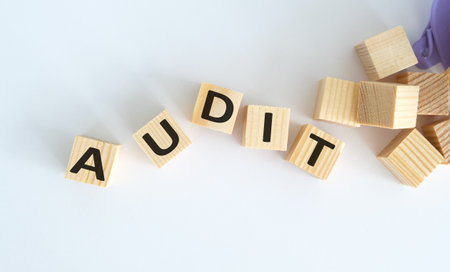 Audit word made of wooden cubes, isolated on white backgroundの写真素材