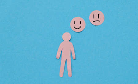 Paper Figure of a Person and emoticons with sad and happy faces, mood change concept, mental healthの写真素材