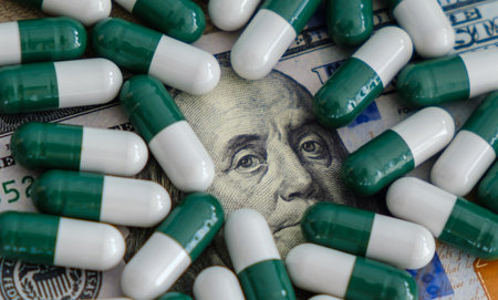 Pills and capsules laying on US dollar banknotesの写真素材