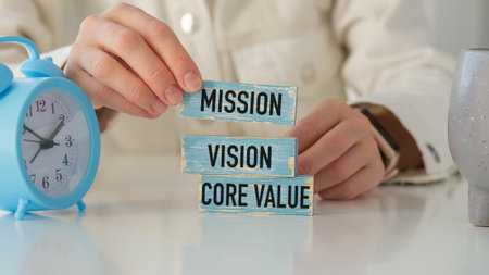 Business man hand holding wooden block with MISSION, VISION, STRATEGY and CORE VALUE text