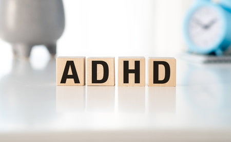 Wooden cubes with the word ADHD on a wooden background and a stethoscope on them. Medical conceptの写真素材