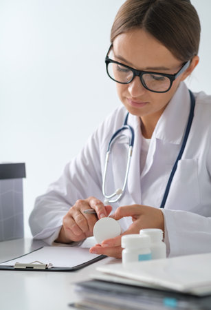 Doctor's hold the composition on a jar of pills, the concept of nutrition, a healthy lifestyle, the selection of a vitamin complexの写真素材