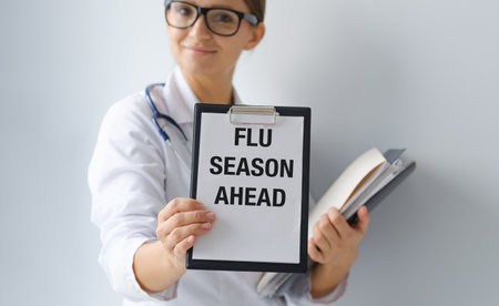 Doctor holding a card with text Flu Season AHEAD, medical concept